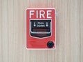 Manual fire alarm activation pull station on modern wooden wall - signage reading: Ã¢â¬ÅFIRE` and Ã¢â¬ÅPULL DOWNÃ¢â¬Â.